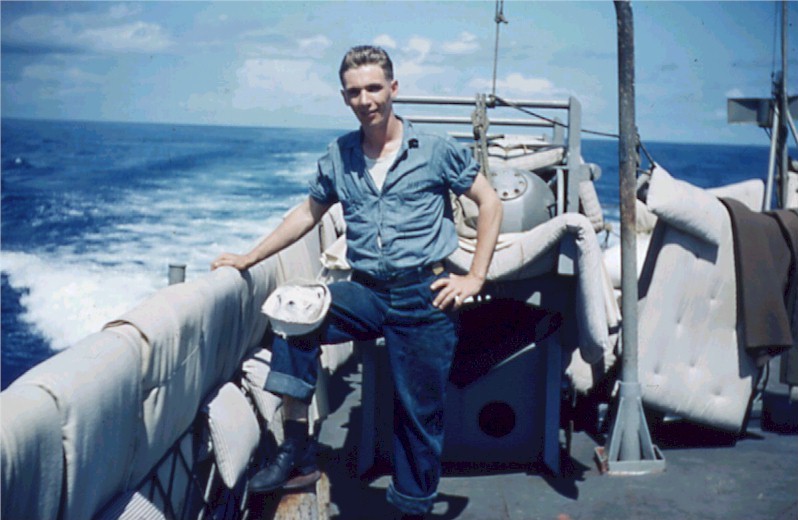 A photo of Harold Jackson on the USS Allen M. Sumner with bedding draped over the railings.