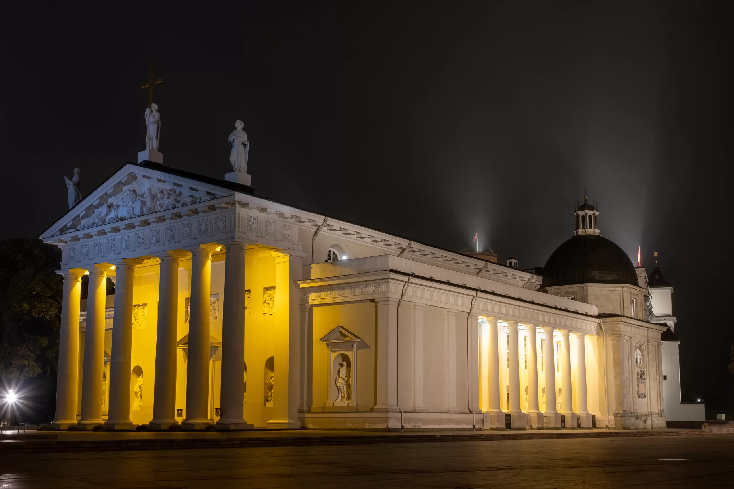 Nighttime photo of Vilnius Cathedral with lights and a dark sky.