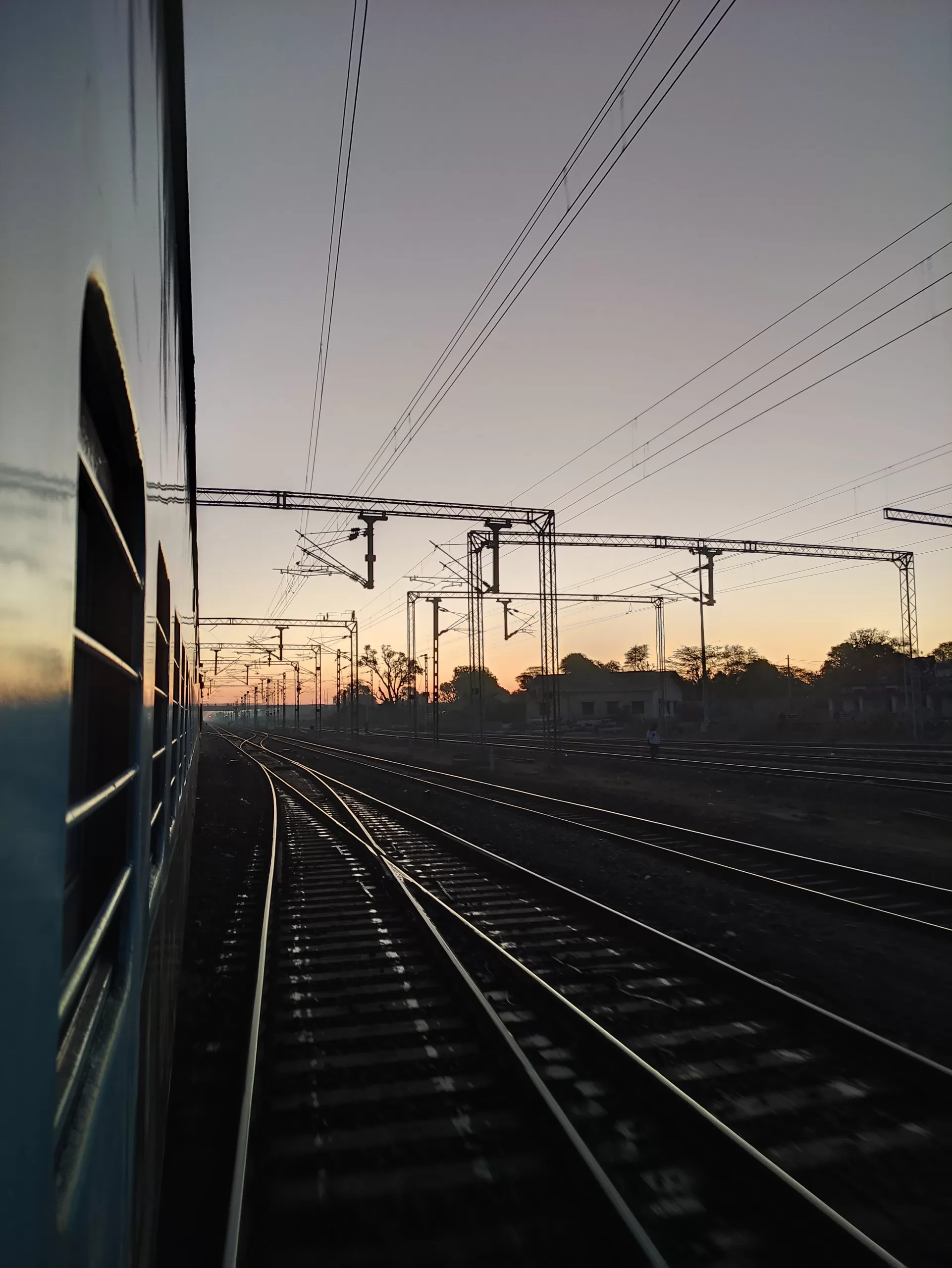 The outside of a train looking down the tracks at dusk