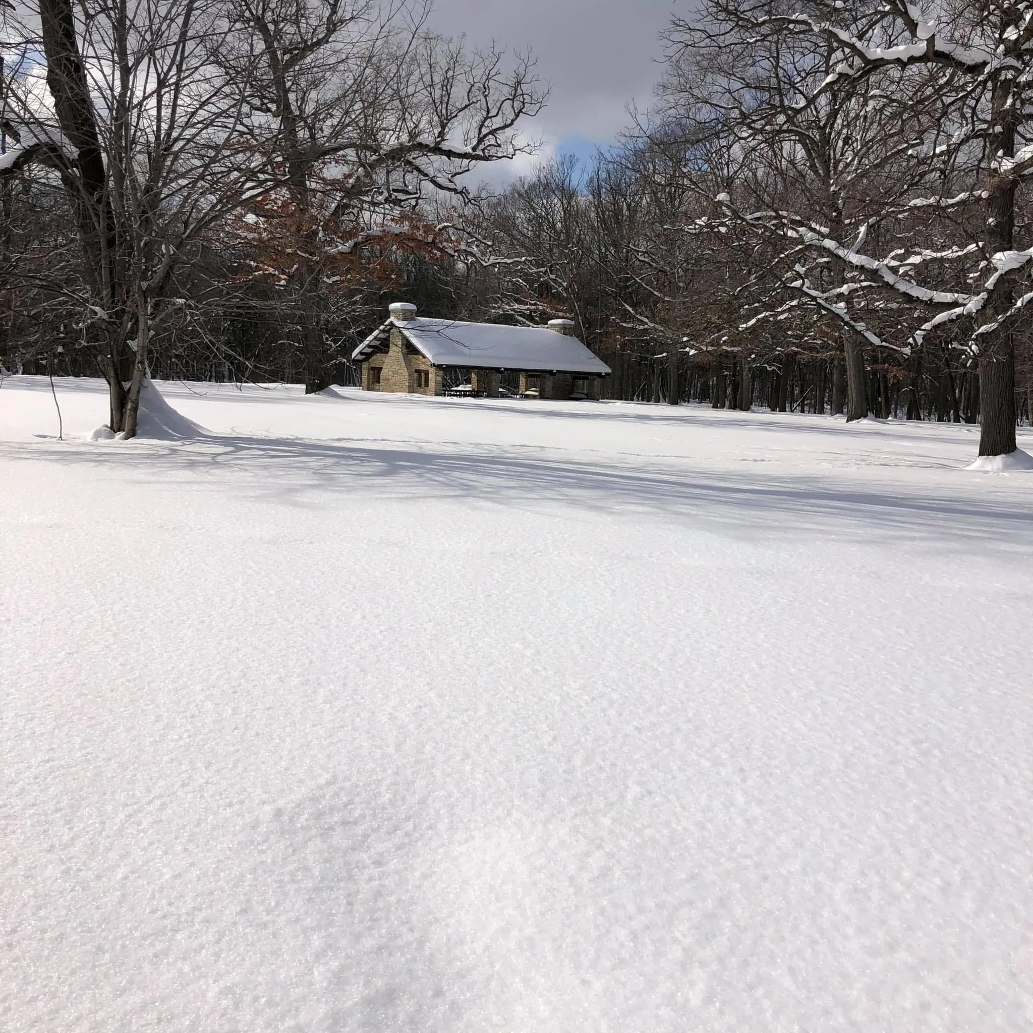 Stone pavilion in a park covered in snow.