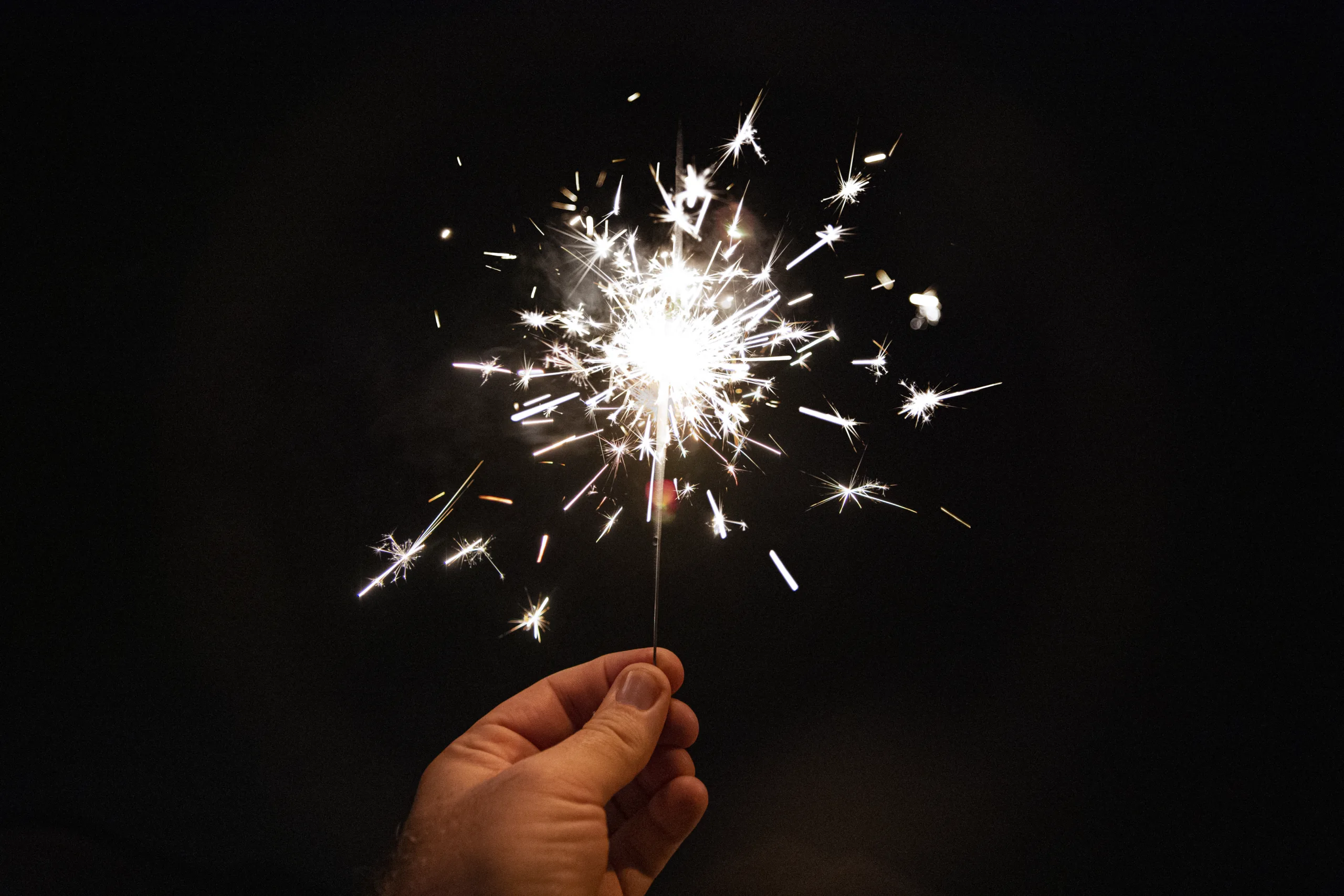 Single sparkler firework at night.