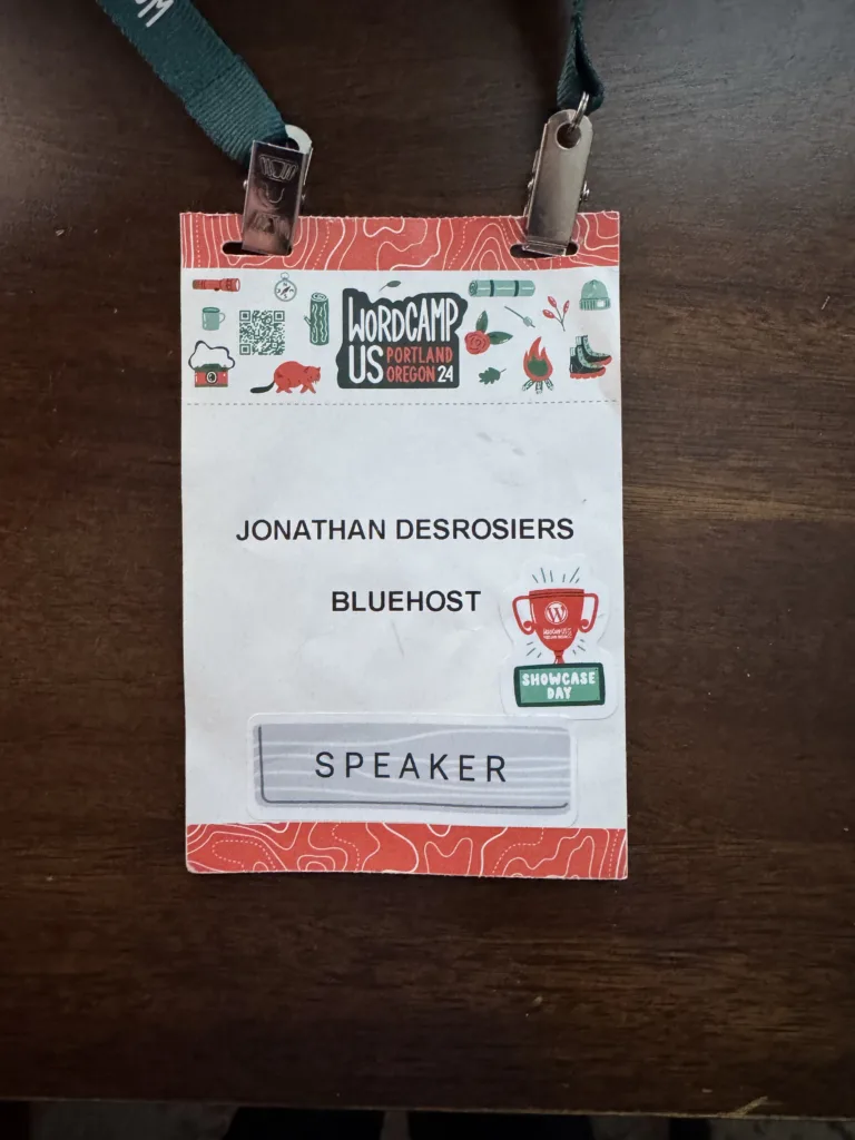 My WordCamp US 2024 speaker badge consisting of an event branded badge with my name and company printed on.