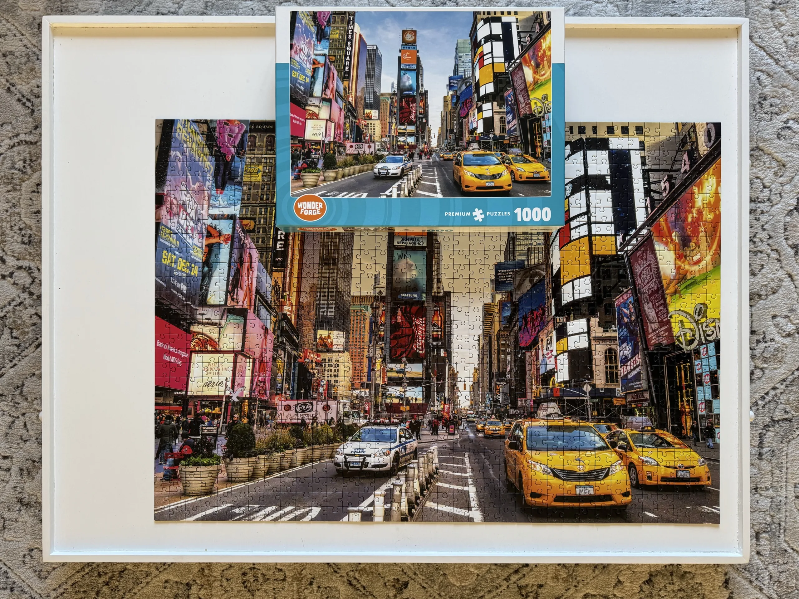 A completed puzzle of Times Square in New York City on a white puzzle board.
