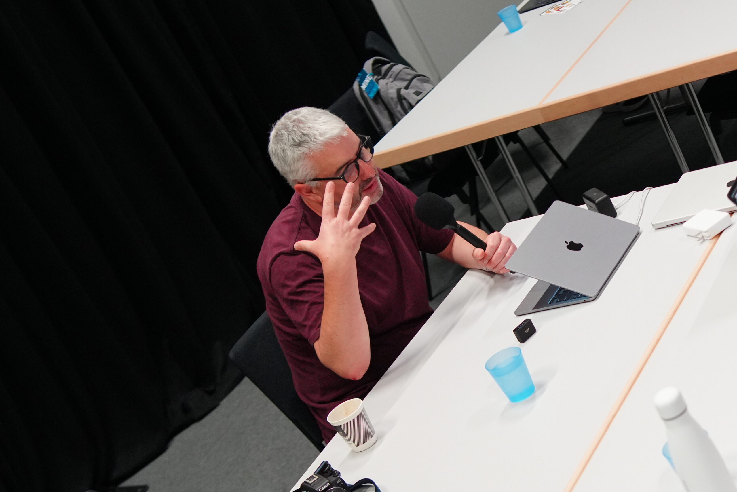 Nathan Wrigley talking into a microphone while motioning with his hand during a recording of the WP Tavern Jukebox podcast.