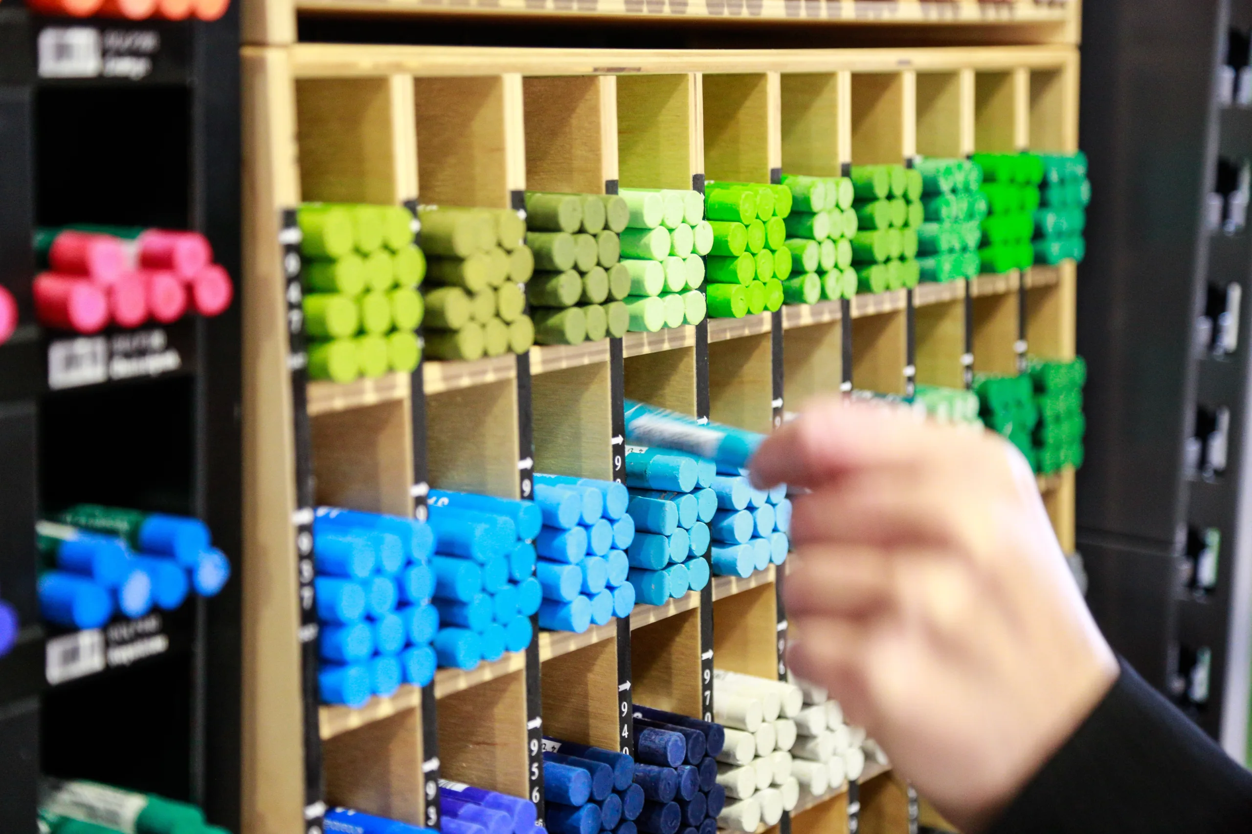 Colored chalk pens organized in a wooden cube shelf.